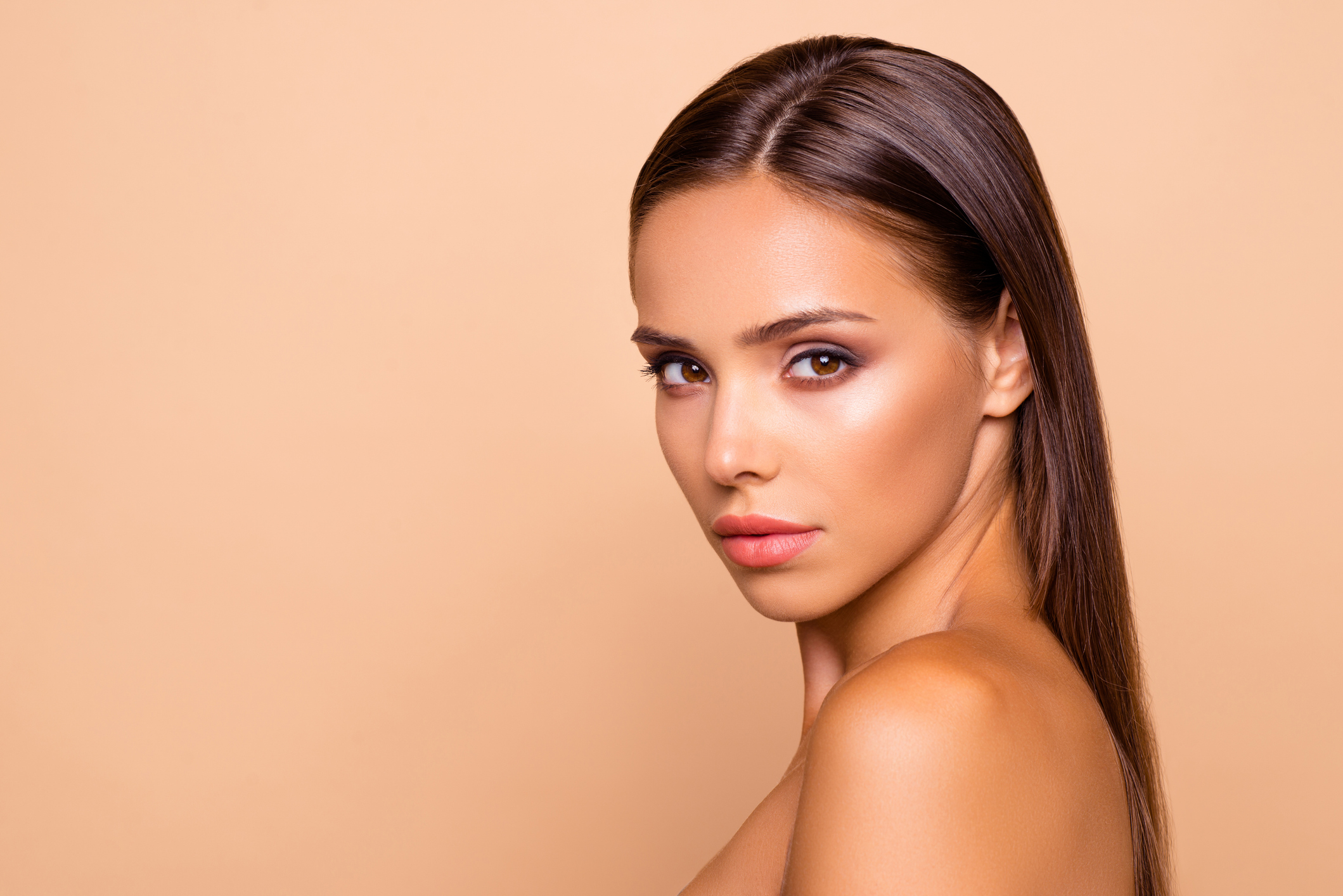 Jawline Filler - Gesicht einer Frau mit langen Haaren in der Seitenansicht